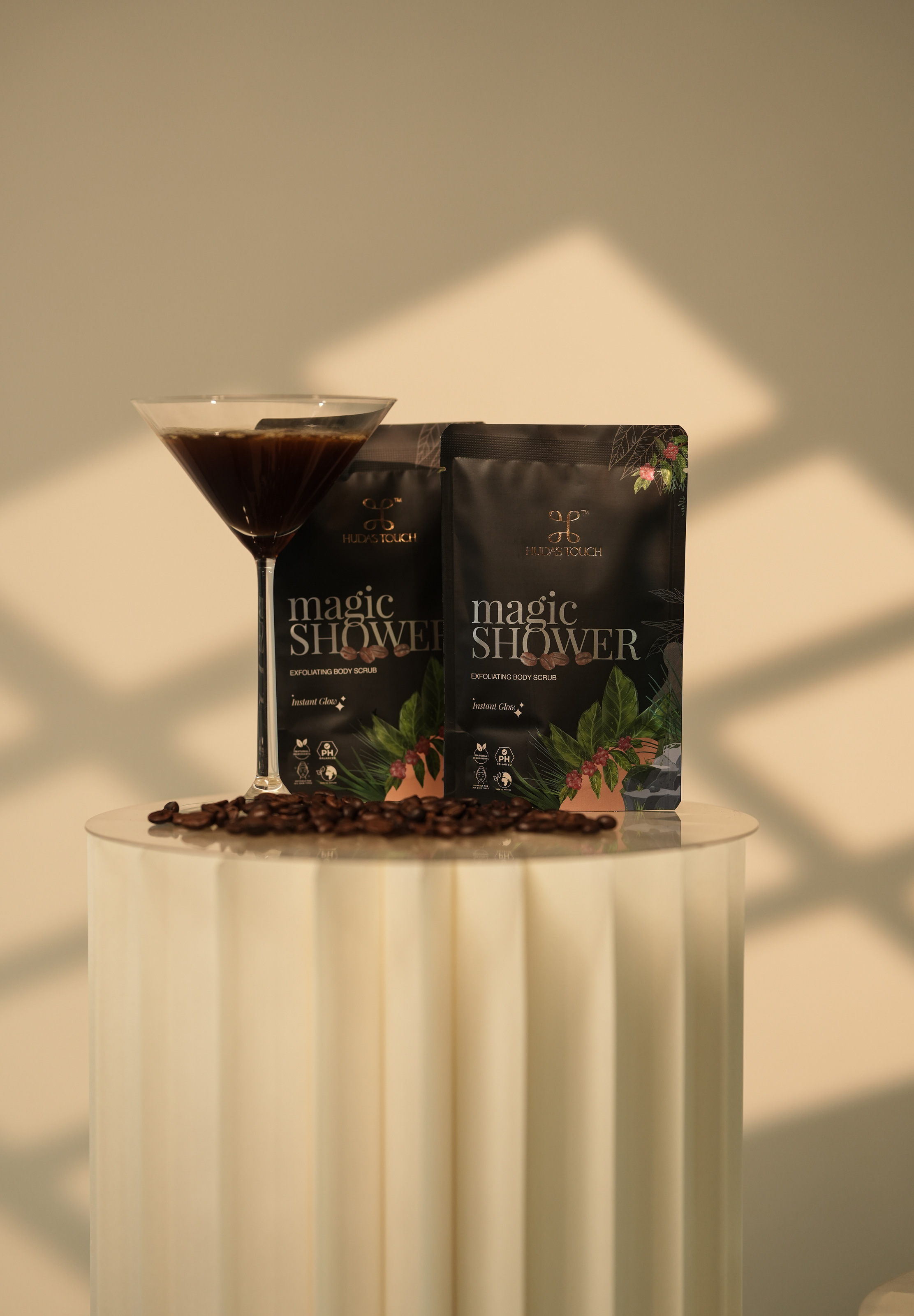 Two sachets with a glass of espresso on a pleated plinth